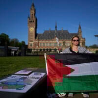 A protester with a Palestinian flag at the International Court of Justice, which opens hearings on a United Nations request for an advisory opinion on Israel's obligations to allow humanitarian assistance into Gaza and the West Bank, in The Hague, Netherlands, April 28, 2025. (AP Photo/Peter Dejong)