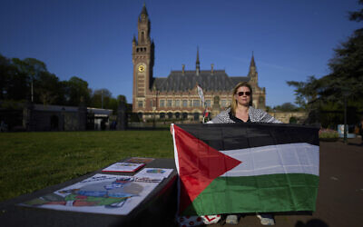 A protestor with a Palestinian flag at the International Court of Justice which opens hearings into a United Nations request for an advisory opinion on Israel's obligations to allow humanitarian assistance in Gaza and the West Bank, in The Hague, Netherlands, April 28, 2025. (AP Photo/Peter Dejong)