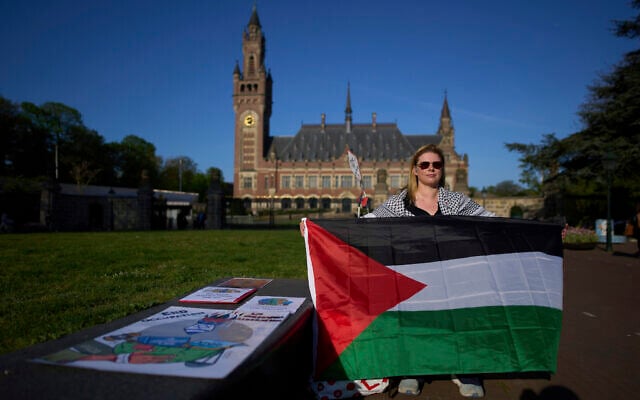 A protester with a Palestinian flag at the International Court of Justice, which opens hearings on a United Nations request for an advisory opinion on Israel's obligations to allow humanitarian assistance into Gaza and the West Bank, in The Hague, Netherlands, April 28, 2025. (AP Photo/Peter Dejong)