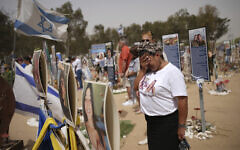 People stand still to observe two minutes of silence as sirens sound marking Israel's annual Memorial Day at the site of Oct. 7, 2023, attack by Hamas terrorists at the Nova music festival near Kibbutz Re'im, southern Israel, April 30, 2025. (AP Photo/Ohad Zwigenberg)