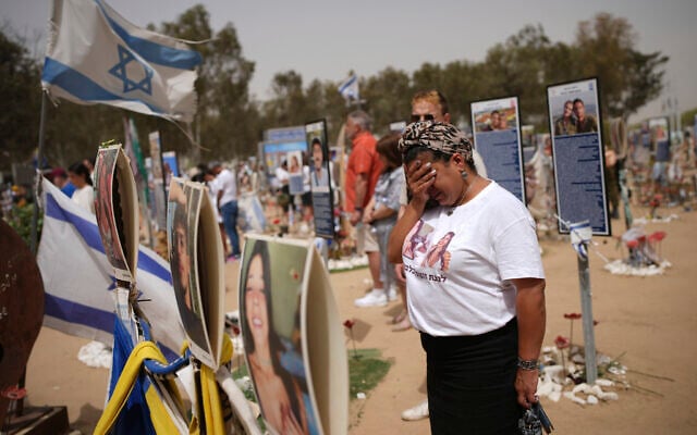People stand still to observe two minutes of silence as sirens sound marking Israel's annual Memorial Day at the site of Oct. 7, 2023, attack by Hamas terrorists at the Nova music festival near Kibbutz Re'im, southern Israel, April 30, 2025. (AP Photo/Ohad Zwigenberg)