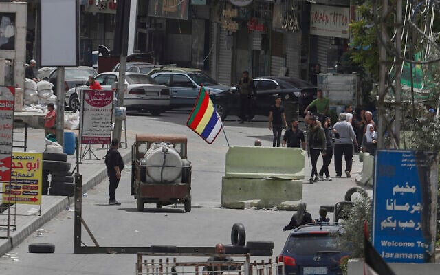 Druze gunmen stand next to their sect's religious flag at a checkpoint at one of the Jaramana suburb entrances, after clashes in the area between members of the minority Druze sect and pro-government fighters, in the southern suburb of Jaramana, Damascus, Syria, April 30, 2025. (AP Photo/Omar Sanadiki)