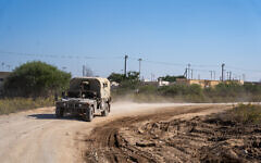IDF vehicles drive outside the Zikim training base in southern Israel, November 16, 2023. (Emanuel Fabian/Times of Israel)