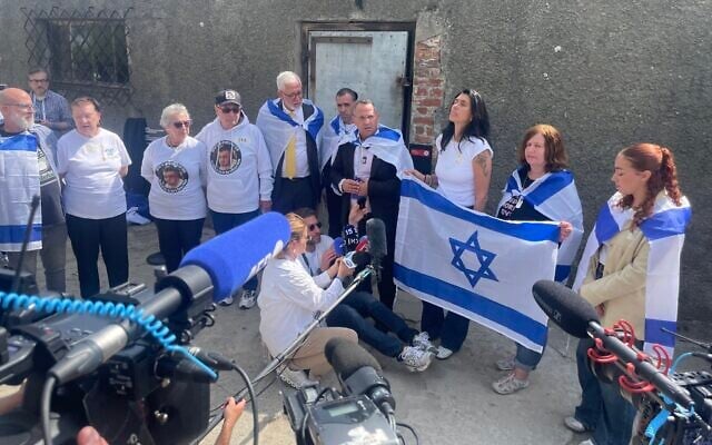 Released hostages and hostages' family members stand outside Auschwitz’s crematorium at March the living on April 24, 2025. (Jessica Steinberg/Times of Israel)
