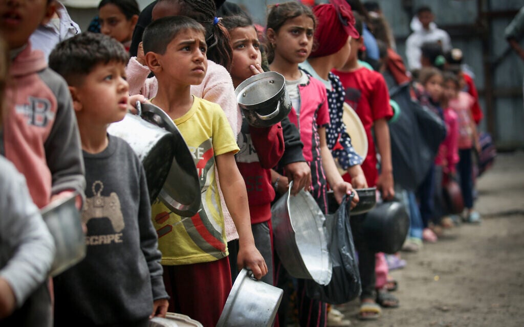 Palestinian children line up in front of a station to receive food in the Nuseirat refugee camp, central Gaza Strip, April 6, 2025 (Ali Hassan/Flash90)