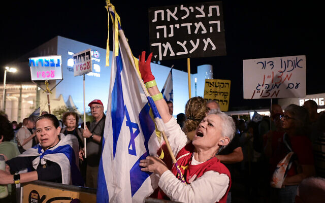 A protest against Prime Minister Benjamin Netanyahu and in support of Shin Bet chief Ronen Bar, as a protestor carries a sign that says, 'Save the country from itself,'  at Habima Square, April 21, 2025 (Photo by Avshalom Sassoni//Flash90)