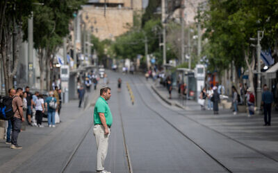 People stand still in Jerusalem as a two-minute siren is sounded across Israel to mark Holocaust Remembrance Day on April 24, 2025. (Chaim Goldberg/Flash90)