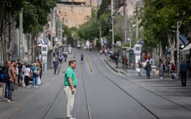 People stand still in Jerusalem as a two-minute siren is sounded across Israel to mark Holocaust Remembrance Day on April 24, 2025. (Chaim Goldberg/Flash90)