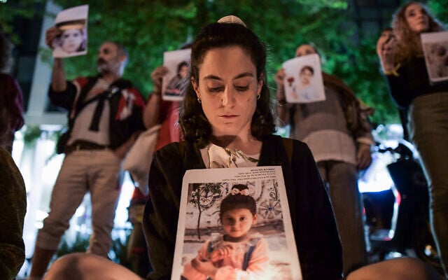 Activists hold up photos of children killed during the war in Gaza, in Tel Aviv, April 26, 2025. (Tomer Neuberg/Flash90)