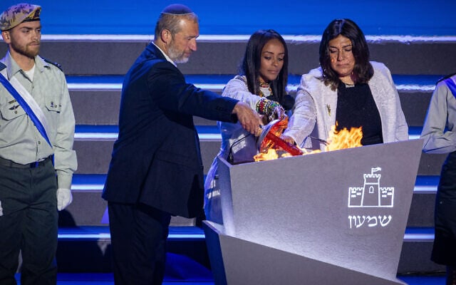 Rabbi Shmuel Slotki, Racheli Tadesa Malkai and Riki Sitton light a torch during a rehearsal for the annual Independence Day ceremony on Mount Herzl, Jerusalem, April 28, 2025. (Yonatan Sindel/Flash90)