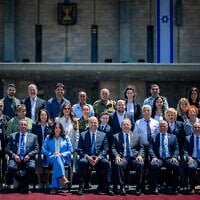 Most of this year's Independence Day torch-lighters pose for a photo outside the Knesset with Knesset Speaker Amir Ohana and Transportation Minister Miri Regev, April 28, 2025. (Yonatan Sindel/Flash90)