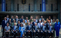 Most of this year's Independence Day torch-lighters pose for a photo outside the Knesset with Knesset Speaker Amir Ohana and Transportation Minister Miri Regev, April 28, 2025. (Yonatan Sindel/Flash90)