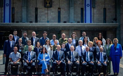 Most of this year's Independence Day torch-lighters pose for a photo outside the Knesset with Knesset Speaker Amir Ohana and Transportation Minister Miri Regev, April 28, 2025. (Yonatan Sindel/Flash90)