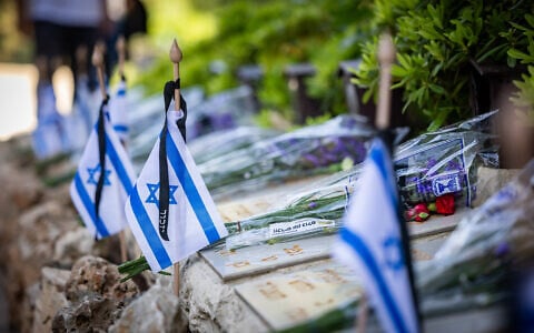 Israeli flags on graves of fallen soldiers in Mount Herzl Military Cemetery in Jerusalem, on April 29, 2025, ahead of Israeli Memorial Day. (Chaim Goldberg/Flash90)