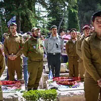 People stand still as a two-minute siren sounded across Israel, marking Memorial Day at Mount Herzl Military Cemetery in Jerusalem on April 30, 2025. (Arie Leib Abrams/Flash90)
