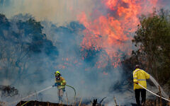 Firefighters try to extinguish a fire that broke out near Mesilat Zion, April 30, 2025. (Noam Revkin Fenton/Flash90)