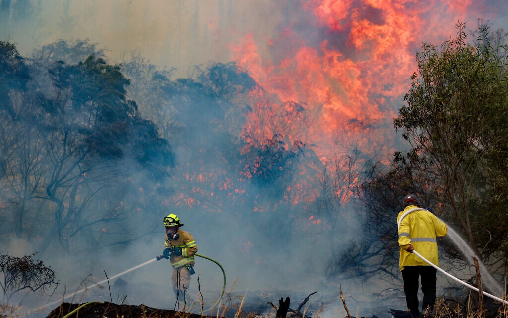 Firefighters try to extinguish a fire which broke out near Moshav Mesilat Zion, April 30, 2025. (Noam Revkin Fenton/Flash90)