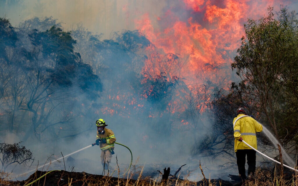 Firefighters try to extinguish a fire which broke out near Moshav Mesilat Zion, April 30, 2025. (Noam Revkin Fenton/Flash90)