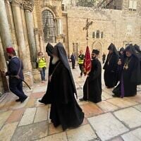 Armenian Christians, accompanied by Israeli volunteers, enter the Church of the Holy Sepulcher on Palm Sunday, April 13, 2025. (Sue Surkes/Times of Israel)