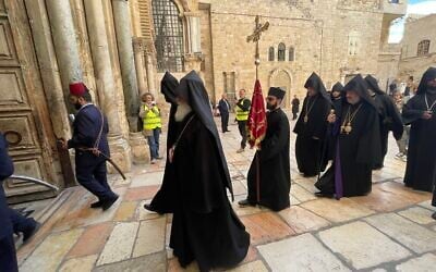 Armenian Christians, accompanied by Israeli volunteers, enter the Church of the Holy Sepulcher on Palm Sunday, April 13, 2025. (Sue Surkes/Times of Israel)