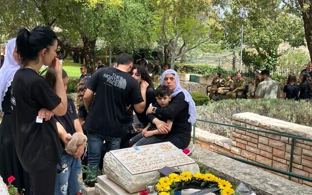 Marwa Gadban, sister of fallen soldier Anwar Serhan, by his grave on April 30, 2025 in Hurfeish (Diana Bletter/Times of Israel)