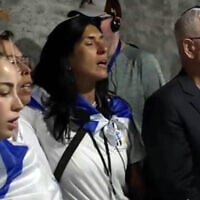 Bereaved Israelis, relatives of hostages and released hostages sing 'Hatikvah' at Auschwitz, April 23, 2025 (Channel 12 screenshot)