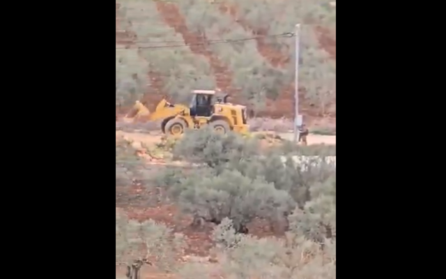 Screenshot of footage posted by Yesh Din showing settlers using a bulldozer to set up an illegal outpost near Turmusaya, West Bank, April 18, 2025. (Yesh Din English / X)