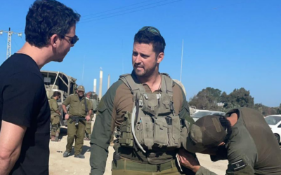 By chance, reserve combat paramedic David Citron (middle) runs into decade-long friend Alan Buch, a New York-based venture capitalist, at the Zikim crossing bordering the Gaza Strip, in December 2023. (Courtesy)
