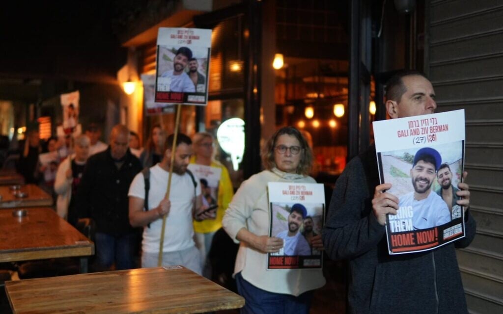 Protesters calling for the release of hostages carry photos of captives Ziv and Gali Berman, in Tel Aviv, April 10, 2025. (Lior Segev/Pro-Democracy Protest Movement)