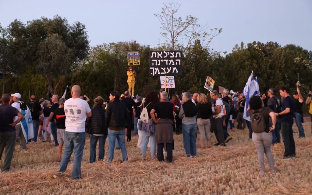 Anti-government protesters rally at Moshav Mazor, where the Netanyahu family is expected for Mimouna celebrations at the end of Passover, April 19, 2025. Placard reads: "Save the country from yourself" (Ilan Faigenbaum / Pro-Democracy Protest Movement)