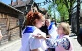Rescued Gaza hostage Ori Megidish, left, with Holocaust survivor Gita Kaufman at Auschwitz on April 23, 2025, a day before March of the Living. (Yossi Zeliger/March of the Living)