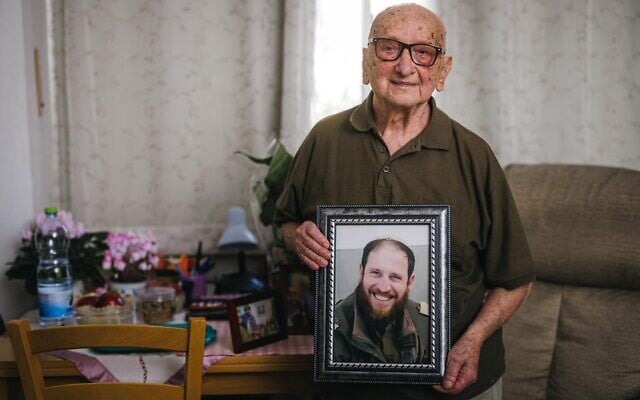 Asher Wolach holds a memorial photo of Rabbi Avi Goldberg, April 2025. (Gal Aharonovich/ International Fellowship of Christians and Jews)