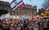 Protesters wave Israeli flags and hold photos of people held hostage by Hamas in Gaza during a demonstration outside the British prime minister's offices in London, November 19, 2023. (Justin Tallis/AFP via Getty Images via JTA)
