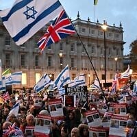 Protesters wave Israeli flags and hold photos of people held hostage by Hamas in Gaza during a demonstration outside the British prime minister's offices in London, November 19, 2023. (Justin Tallis/AFP via Getty Images via JTA)