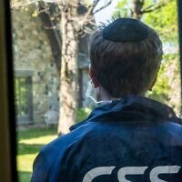 A CSS volunteer stands guard outside a synagogue during a security training drill, in Westchester County, New York, April 28, 2025. (Luke Tress/Times of Israel)