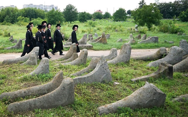 Young Hasidic men walk in an 18th century Jewish cemetery in the small Ukrainian town of Berdychiv, July 30, 2018. (Sergei SUPINSKY / AFP)