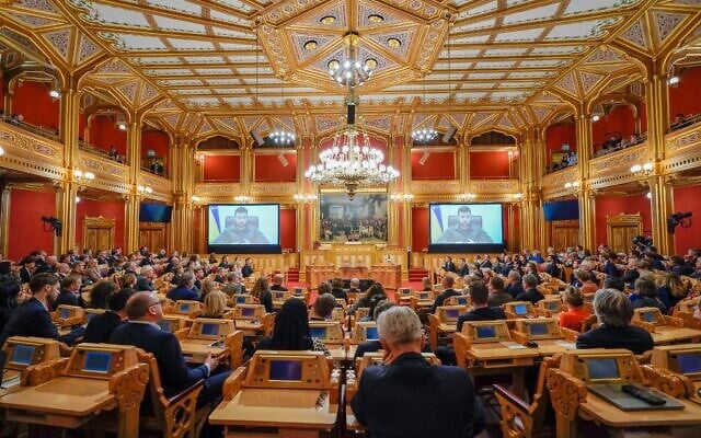 Illustrative: Ukrainian President Volodymyr Zelensky is seen on large screens as he addresses members of Norway's Parliament, The Storting, in Oslo, Norway on March 30, 2022. (Heiko JUNGE / various sources / AFP)