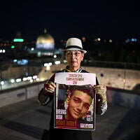 Varda Ben Baruch holds an image of her grandson, hostage Edan Alexander, in Jerusalem on October 25, 2023. (Yuri CORTEZ / AFP)