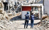 Journalists film while standing before destroyed buildings in the Jabalia camp for Palestinian refugees in the northern Gaza Strip on October 9, 2024. (Omar AL-QATTAA / AFP)