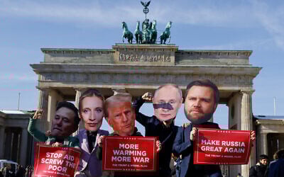 Activists wearing masks of (L-R) Tesla and SpaceX CEO Elon Musk, Co-leader and main candidate of the far-right Alternative for Germany (AfD) party Alice Weidel, US President Donald Trump, Russian President Vladimir Putin and US Vice President JD Vance, hold up placards as they stage a protest against the support of the US and Russia for the far-right AfD party in front of the landmark Brandenburg Gate in Berlin, on February 20, 2025. (David Gannon/AFP)