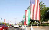 The flags of the US and Iran hang on the road leading to the Muscat International Book fair on April 25, 2025. (Haitham al-Shukairi/AFP)