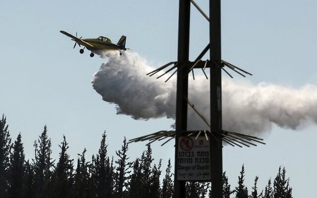 A firefighting plane drops flame retardant while trying to extinguish a forest fire near Beit Shemesh, on May 2, 2025. (Ahmad Gharabli/AFP) A firefighting plane drops flame retardant while trying to extinguish a forest fire near Beit Shemesh, on May 2, 2025. (Ahmad Gharabli/AFP)
