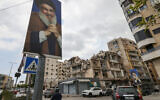 People drive on a street past portraits of slain Lebanese Hezbollah leader Hassan Nasrallah and buildings damaged in Israeli strikes in the recent war, amid the first round of municipal elections, in the Ghobeiry neighbourhood of Beirut's southern suburb on May 4, 2025. (ANWAR AMRO / AFP)