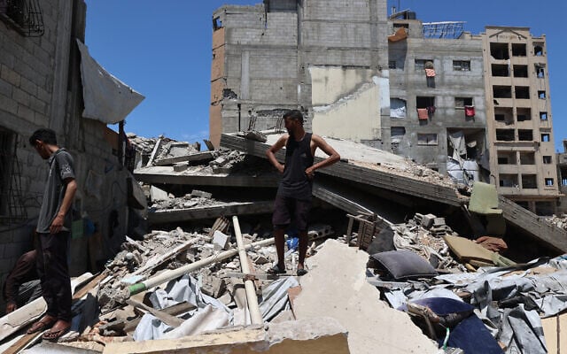 Palestinians inspect the damage following overnight Israeli strikes, at the Nuseirat camp in the central Gaza Strip on May 4, 2025 (Eyad BABA / AFP)