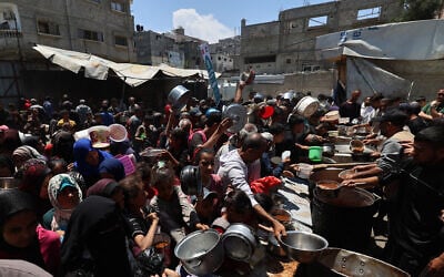 Palestinians queue for a hot meal at a charity kitchen at the Nuseirat refugee camp in the central Gaza Strip on May 4, 2025. (Eyad BABA / AFP)