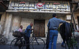 People walk past the closed entrance of al-Karawan nightclub after it was attacked by gunmen on May 5, 2025. (Omar Haj Kadour / AFP)