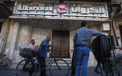 People walk past the closed entrance of al-Karawan nightclub after it was attacked by gunmen on May 5, 2025. (Omar Haj Kadour / AFP)