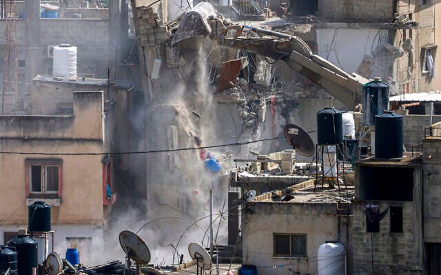 An Israeli army excavator demolishes a Palestinian building in a refugee camp east of Tulkarem, on May 5, 2025, during an ongoing military operation in the north of the West Bank (Jaafar ASHTIYEH / AFP)