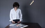 Iranian filmmaker and activist Sepideh Farsi looks at a portrait of the Palestinian photographer Fatima Hassouna, during a photo session at her home in Paris on May 5, 2025. (JOEL SAGET / AFP)