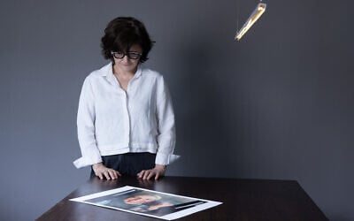 Iranian filmmaker and activist Sepideh Farsi looks at a portrait of the Palestinian photographer Fatima Hassouna, during a photo session at her home in Paris on May 5, 2025. (JOEL SAGET / AFP)